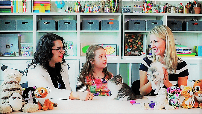 Mieshelle and adult and child seated at table holding cats | Mieshelle Nagelschneider | Cat Behaviorist | thecatbehaviorclinic.com